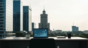 Panorama biznesowej dzielnicy Warszawy w dzień, nowoczesne wiezowce i biurko z laptopem prezentujacym wykresy widocznosc